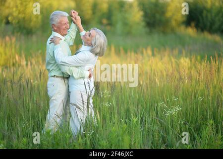 Happy senior couple dancing in summer park Banque D'Images