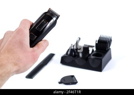Main de coiffeur tenant le razer sans fil isolé sur un whiet et les accessoires sur l'arrière-plan. Banque D'Images