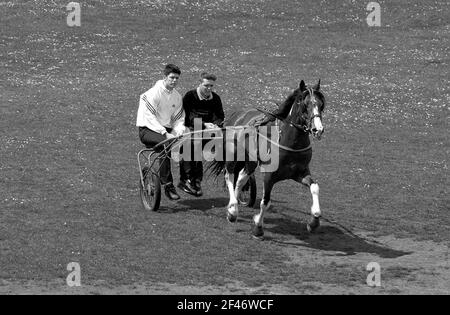 Deux jeunes hommes à cheval de style tzigane ou en voiture de course ou en suloky dans Bilston West Midlands UK en 2001. Britain sulky Racing man homme romany adolescents adolescent Banque D'Images