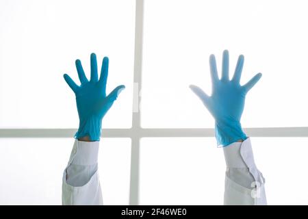 image rognée d'un médic dans des gants de protection debout avec ses mains vers le haut . Banque D'Images