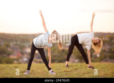 mère et fille sportives. entraînement de femme et d'enfant dans le parc. sports de plein air. mode de vie sportif sain. fitness, yoga. Banque D'Images