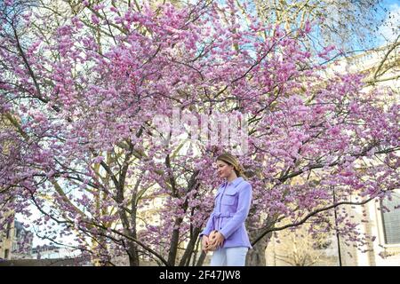 Londres, Royaume-Uni. 19 mars 2021. Les gens posent pour des photos devant des arbres en fleurs, en face de la cathédrale Saint-Paul à Londres. Date de la photo : vendredi 19 mars 2021. Crédit photo devrait lire crédit: Matt Crossick/Alamy Live News Banque D'Images