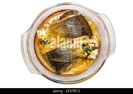 Morceaux de carpe cuits dans un bol en verre avec du beurre fondu, du persil et des tranches de citron, isolés sur un fond blanc avec un chemin d'écrêtage, vue du dessus. Banque D'Images