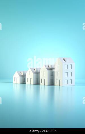 Quelle taille de maison pouvez-vous vous permettre ? Plan de concept: Quatre modèles de maisons de différentes tailles sur fond bleu. Espace de copie disponible. Banque D'Images