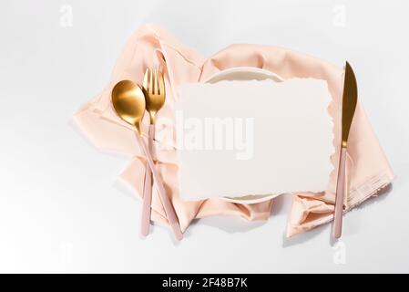 Table joliment décorée avec des assiettes blanches, couverts aux pommes dorées sur des nappes beiges luxueuses Banque D'Images