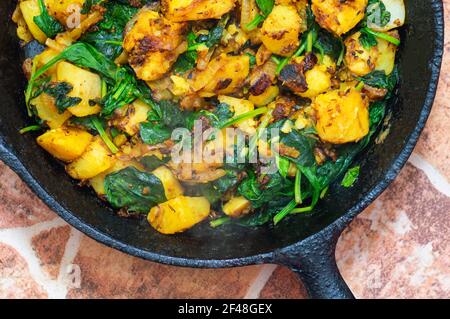 Saag Aloo, épinards et pommes de terre de style indien dans une casserole en fonte Banque D'Images