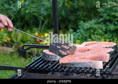 Processus de préparation du saumon sur le gril en bois. Steaks de poisson grillés au feu. Banque D'Images