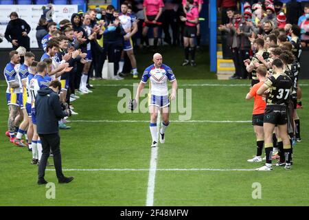 Chris Hill (au centre) de Warrington Wolves se rend à une garde d'honneur avant son match de témoignage au stade Halliwell Jones, à Warrington. Date de la photo : vendredi 19 mars 2021. Banque D'Images