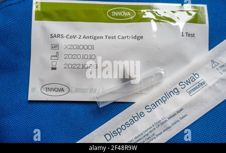 Kit de test de l'antigène SARS-CoV-2 appartenant à Innova Medical Group Inc., États-Unis et distribué par TAS&Tested.TECH, fabriqué par Xiamen Biotechnology Co, Ltd., Chine. Kit de test de débit latéral du coronavirus Covid 19 comprenant un écouvillon d'échantillonnage jetable et une cartouche de test, Royaume-Uni. Sur un arrière-plan en tissu bleu. Banque D'Images