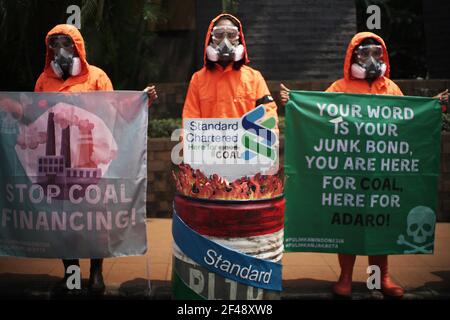 Jakarta, DKI Jakarta, Indonésie. 19 mars 2021. Un certain nombre de militants écologistes qui ont participé à la pause pour l'action climatique à l'aide d'un équipement de protection individuelle complet ont organisé un rassemblement devant la tour Standard Caharbtered, Jakarta, le vendredi 19 mars 2021. En action, ils ont appelé les gouvernements et les dirigeants de l'industrie à prendre des responsabilités et à prendre conjointement des mesures concrètes pour le sauvetage climatique, dont l'une est de cesser de financer l'industrie mortelle des combustibles fossiles. Crédit : Muhammad Zaenuddin/ZUMA Wire/Alay Live News Banque D'Images