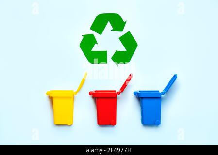 Bacs de recyclage jaune, rouge et bleu avec symbole de recyclage sur fond bleu. Concept de recyclage Banque D'Images