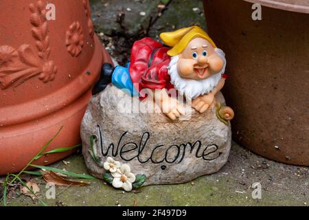 Gnome de bienvenue parmi les pots en terre cuite dans un jardin anglais Banque D'Images