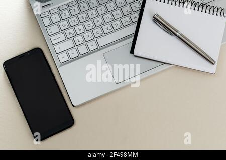 Vue de dessus d'un bureau avec un ordinateur portable, un ordinateur portable, un stylet et un smartphone. Copier l'espace. Banque D'Images