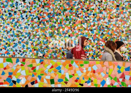 Düsseldorf, NRW, Allemagne. 19 mars 2021. Les gens dans les masques faciaux marchent devant le mur de mosaïque 'Rivertime' par Hermann-Josef Kuhna sur les rives du Rhin à Dusseldorf, capitale du NRW. Les mesures de confinement devraient augmenter une fois de plus en Allemagne, le taux d'incidence sur 7 jours atteignant un seuil crucial de 100 000 habitants. Alors que Düsseldorf s'élève relativement bien à 63 aujourd'hui, l'Allemagne a globalement vu les chiffres augmenter à 95.6 crédit: Imagetraceur/Alamy Live News Banque D'Images