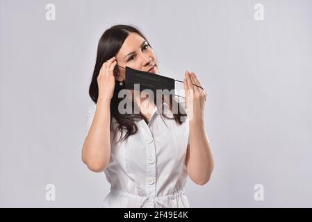 La jeune femme porte un masque de protection noir Banque D'Images