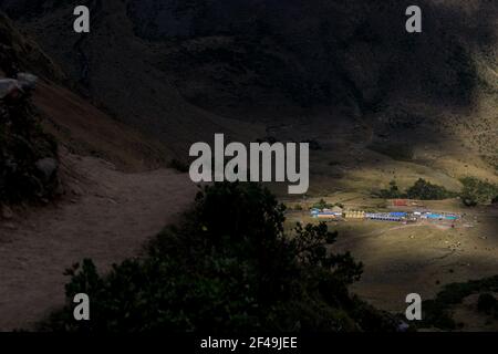 Lumière chaude et ensoleillée tombant au-dessus du camp de Salkantaypampa vu depuis le sentier menant au lac Humantay sur le trek de Salktantay au Pérou. Trekking aventure Banque D'Images