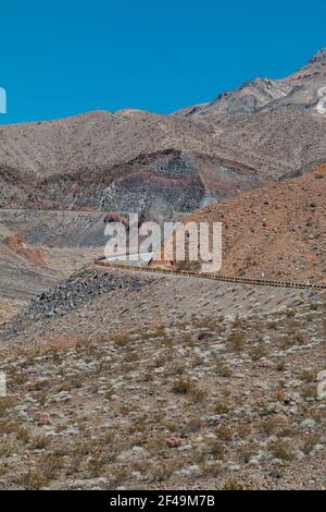 Une route vide qui se courbe à travers un paysage de montagne dans la mort Vallée Banque D'Images