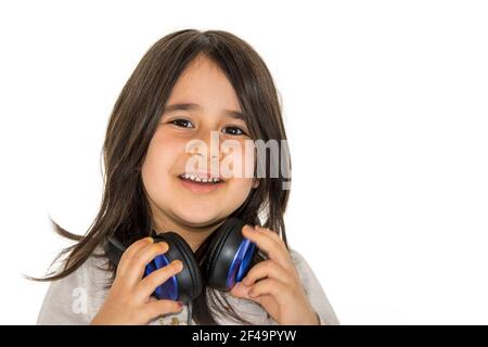 Petite fille regardant vers l'appareil photo et souriant tout en tenant le casque Banque D'Images