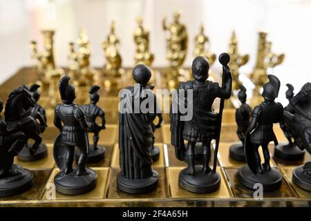 Arrière de la reine noire, le roi centurion et la pièce d'échecs de chevalier figurines sur échiquier face à l'or opposé de l'armée Banque D'Images