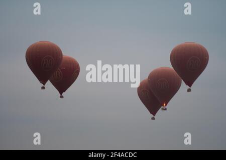 BAGAN, NYAUNG-U, MYANMAR - 2 JANVIER 2020 : cinq ballons rouges à air chaud s'élèvent dans le ciel ensemble pour les touristes Banque D'Images