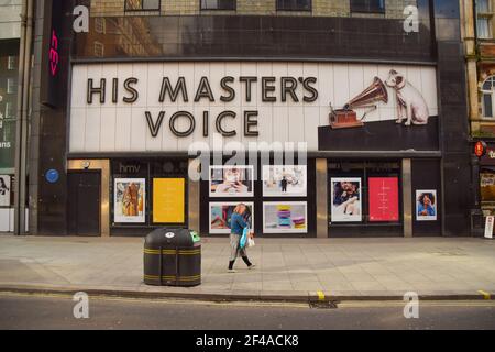 Une femme passe devant le magasin phare de HMV (sa voix de maître) sur Oxford Street, qui est inoccupé depuis sa fermeture permanente en 2019.cette année, le détaillant de musique, de film et de jeux célèbre le 100e anniversaire de l'ouverture de son premier magasin. Banque D'Images
