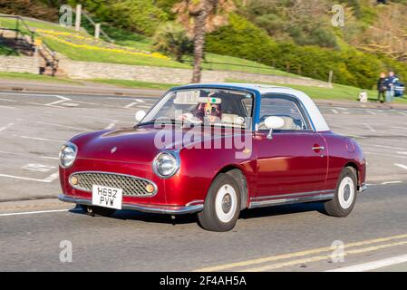 Nissan Figaro conduite à Southend on Sea, Essex, Royaume-Uni. modèle 1991. Petite voiture décapotable en édition limitée, rouge magenta non standard Banque D'Images