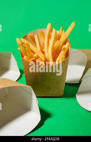 Boîtes de frites savoureuses sur fond de couleur Banque D'Images