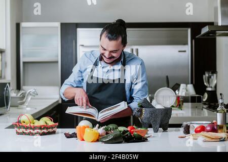 latino-homme cuisant à la maison de la salade ou de la sauce mexicaine Dans la cuisine à la maison dans la ville de Mexico Banque D'Images