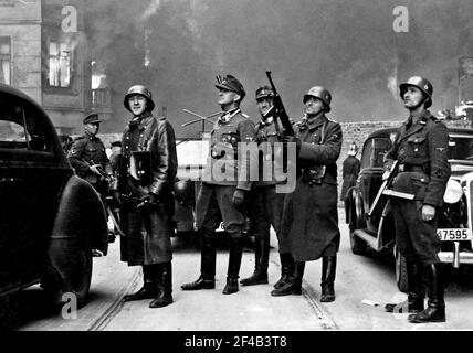 Blösche à droite, à côté de lui est Heinrich Klaustermeyer, à gauche est Karl Kaleske ou Erich Steidtmann avec Jürgen Stroop à gauche regardant des blocs de logements brûler pendant le soulèvement du ghetto de Varsovie. Photo prise à la rue Nowolipie en direction de l'est, près de l'intersection avec la rue Smocza. Sur le balcon à gauche de la maison Nowolipie 66. Banque D'Images
