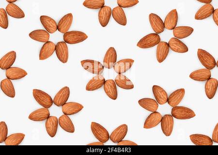 Motif sans couture de fleurs d'amande. 6 amandes crues disposées en forme de fleur. Concept pour les avantages pour la santé de manger des noix, régime à base de plantes. Banque D'Images