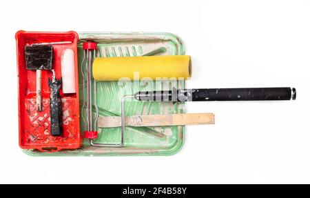 Outils de peinture bien utilisés. Vue de dessus des plateaux à peinture, du rouleau en mousse, de la tige d'extension, du bâton de bois et de la brosse à découper. Concept pour rénovation maison et touc Banque D'Images