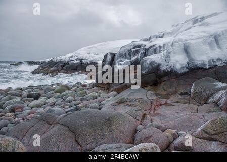 Des falaises gelées sur les rives de l'océan Arctique le jour sombre de février. Quartier du village de Teriberka. Région de Mourmansk, Russie Banque D'Images
