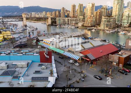 Marché public et marina de Granville Island au crépuscule. La ville de Vancouver construit l'horizon et le pont de la rue Burrard en arrière-plan. Vancouver, Canada. Banque D'Images