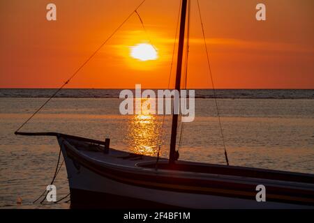 Pêcheur sur son bateau au coucher du soleil sur la plage de Flic en Flac, Maurice Banque D'Images