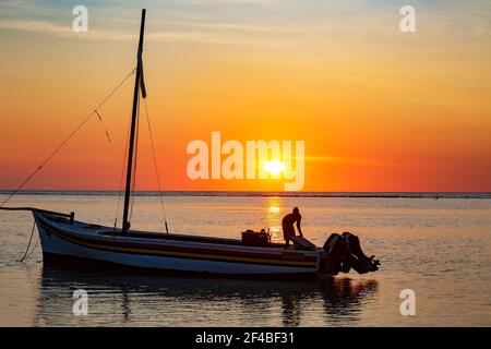 Pêcheur sur son bateau au coucher du soleil sur la plage de Flic en Flac, Maurice Banque D'Images