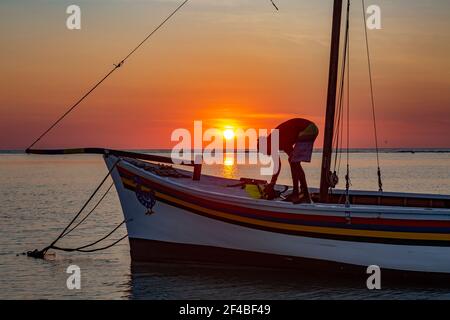 Pêcheur sur son bateau au coucher du soleil sur la plage de Flic en Flac, Maurice Banque D'Images