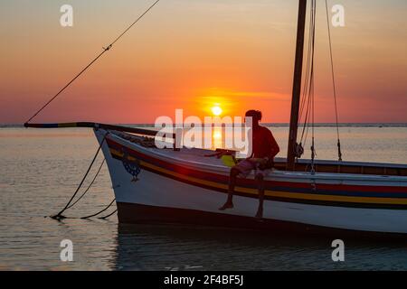 Pêcheur sur son bateau au coucher du soleil sur la plage de Flic en Flac, Maurice Banque D'Images