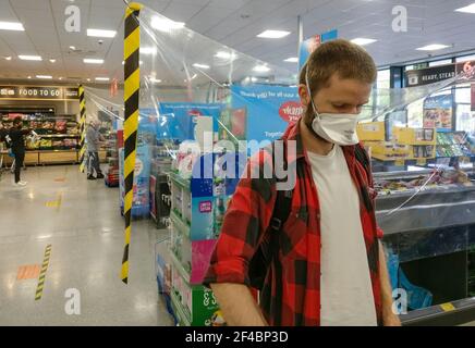 Londres, Royaume-Uni - 21 août 2020 : jeune homme inconnu portant un masque respiratoire lors de ses achats dans un supermarché. Les masques de virus sont obligatoires insi Banque D'Images