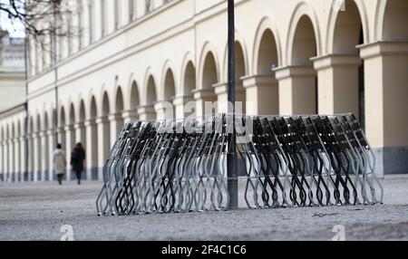 Munich, Allemagne. 20 mars 2021. Les chaises de jardin de bière sont alignées dans le jardin de cour, enchaînées et penchées contre une lanterne. Credit: Tobias Hase/dpa/Alay Live News Banque D'Images