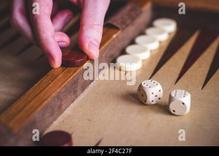 Jouer au jeu de backgammon. L'homme joue à un jeu de société. Dés sur une planche en bois Banque D'Images