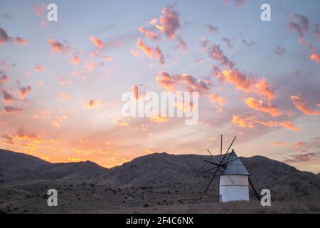 moulin au coucher du soleil entouré de collines à Cabo de Gata, Andalousie, Espagne Banque D'Images
