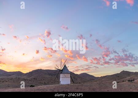 moulin au coucher du soleil entouré de collines à Cabo de Gata, Andalousie, Espagne Banque D'Images