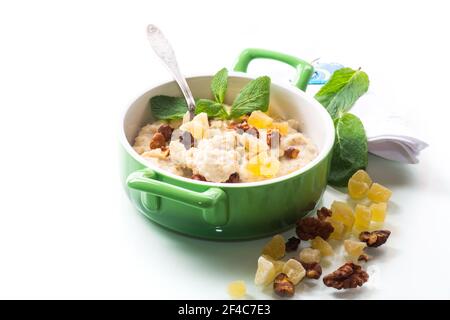 flocons d'avoine sucrés cuits, avec noix et fruits confits un bol isolé sur fond blanc Banque D'Images