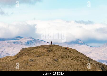 Dumgoyne, CAMPSIE Fells, Écosse, Royaume-Uni. 20 mars 2021. Météo au Royaume-Uni - marcheurs au sommet de Dumgoyne, un site bien connu visible de Glasgow lors d'un autre jour de printemps chaud mais frémissant dans les Fells de CAMPSIE. Les Trossachs lointains créent une toile de fond spectaculaire. Crédit : Kay Roxby/Alay Live News Banque D'Images