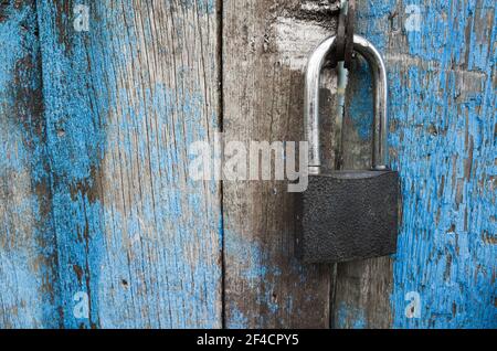 Cadenas accroché à une porte en bois bleu grind. Gros plan Banque D'Images