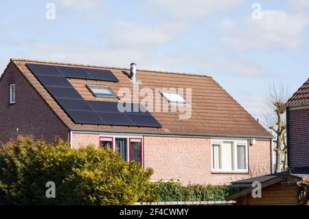 Maison avec un toit marron avec panneaux solaires pour l'électricité production d'énergie Banque D'Images