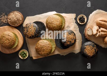 Pain végétalien sans gluten et pains divers types avec sarrasin, spiruline, charbon de bois sur fond noir. Vue de dessus. Banque D'Images