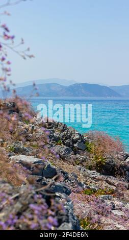 Vue verticale sur la côte rocheuse et l'eau de mer turquoise. Vue sur la mer avec montagnes. Concept de vacances d'été au bord de la mer Banque D'Images