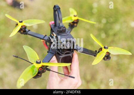 Un flic de drone de course à grande vitesse fpv allongé sur une main Banque D'Images