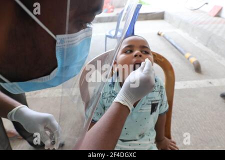 Dhaka, Dhaka, Bangladesh. 20 mars 2021. Le 20 mars 2021 un employé portant un écran facial prélève un échantillon d'écouvillon auprès d'un résident qui sera soumis à un test de dépistage du coronavirus. Mugda Medical College and Hospital à Dhaka, Bangladesh Credit: Harun-or-Rashid/ZUMA Wire/Alamy Live News Banque D'Images